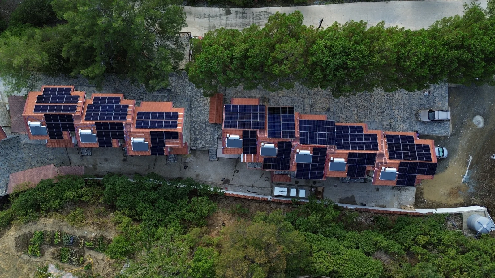 Aerial view of solar panels on the red-tiled roofs of a hotel complex in Kato Platres