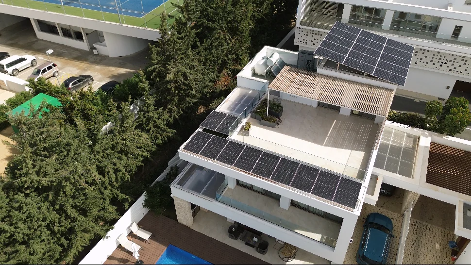 Aerial view of a home in Kissonerga with solar panels on the upper roof and around the terrace