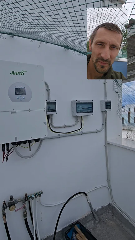 Inverter Jinko και ηλεκτρικοί πίνακες στον τοίχο, με τον παρουσιαστή σε ένθετο του βίντεο